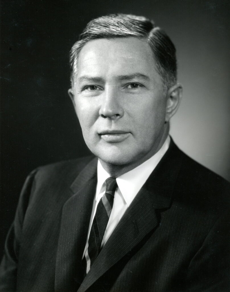 Portrait of Dean William J Haggerty in a dark suit and tie.